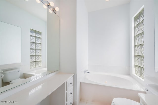 bathroom featuring toilet, a healthy amount of sunlight, a bath, and vanity