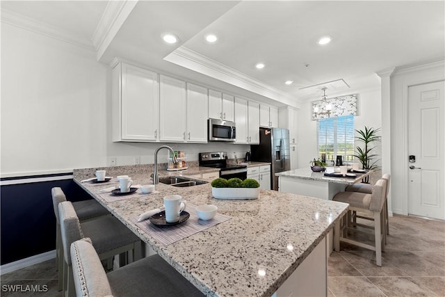 kitchen featuring a kitchen bar, a kitchen island, appliances with stainless steel finishes, and a sink