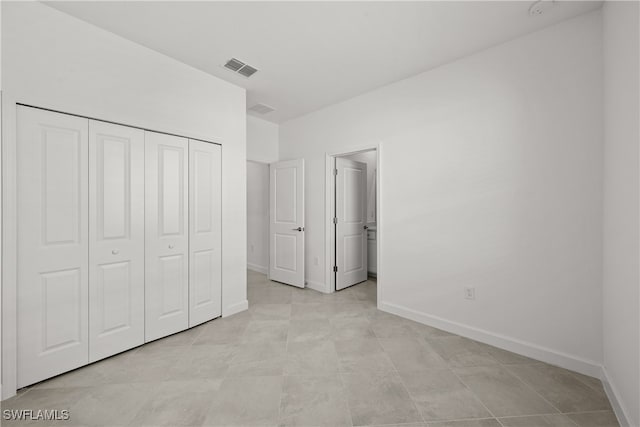 unfurnished bedroom with a closet, visible vents, and baseboards