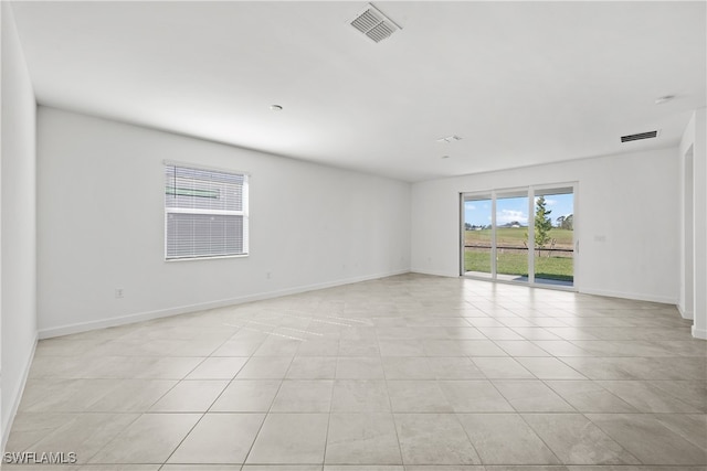 unfurnished room featuring light tile patterned floors, baseboards, and visible vents