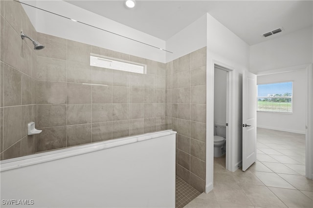 full bathroom featuring a walk in shower, toilet, visible vents, tile walls, and tile patterned floors