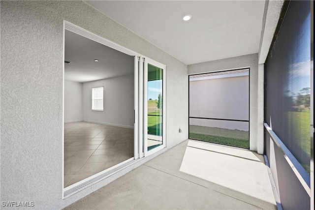 interior space with recessed lighting, light tile patterned flooring, and a textured wall