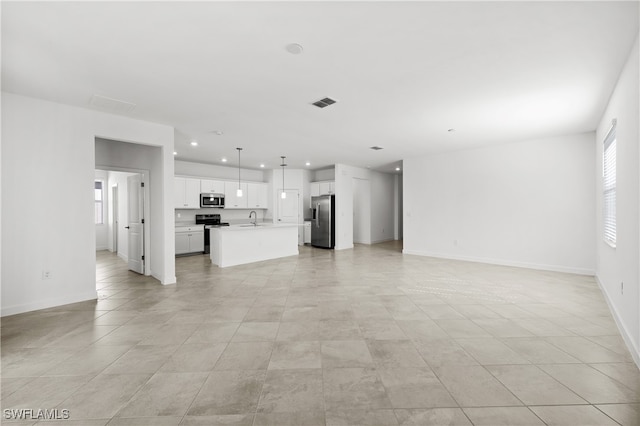 unfurnished living room with recessed lighting, visible vents, a sink, and baseboards