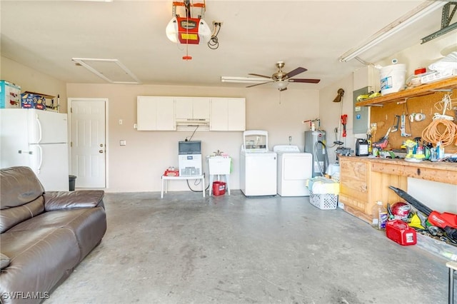 garage featuring a workshop area, a garage door opener, freestanding refrigerator, washing machine and dryer, and a sink