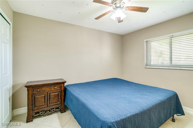 bedroom with ceiling fan, baseboards, and light tile patterned flooring