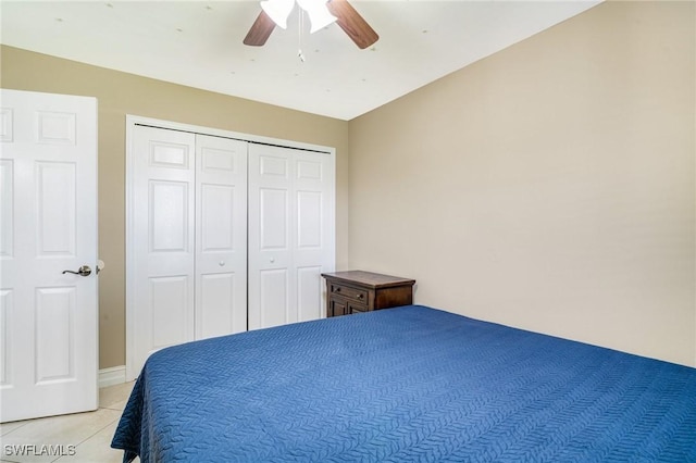 bedroom with light tile patterned floors, a closet, and a ceiling fan