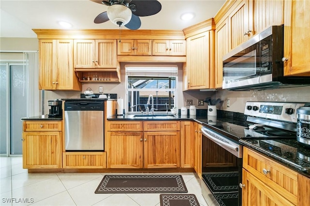 kitchen with appliances with stainless steel finishes, light tile patterned flooring, a sink, and a ceiling fan