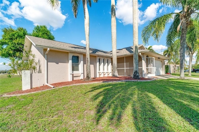 view of front of home with a front lawn, an attached garage, and stucco siding