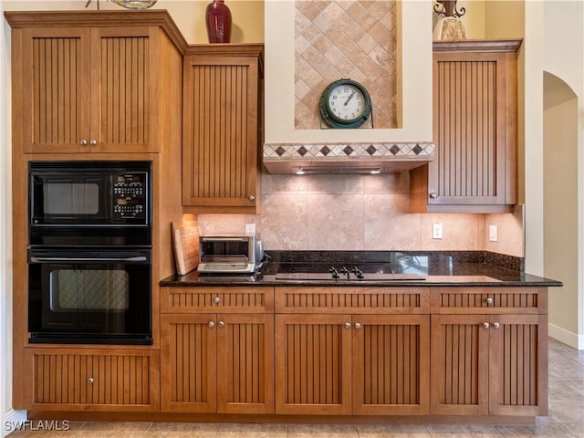 kitchen featuring decorative backsplash, dark stone counters, a toaster, and black appliances