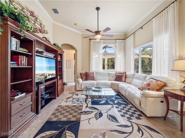 living room featuring arched walkways, crown molding, light tile patterned floors, visible vents, and ceiling fan