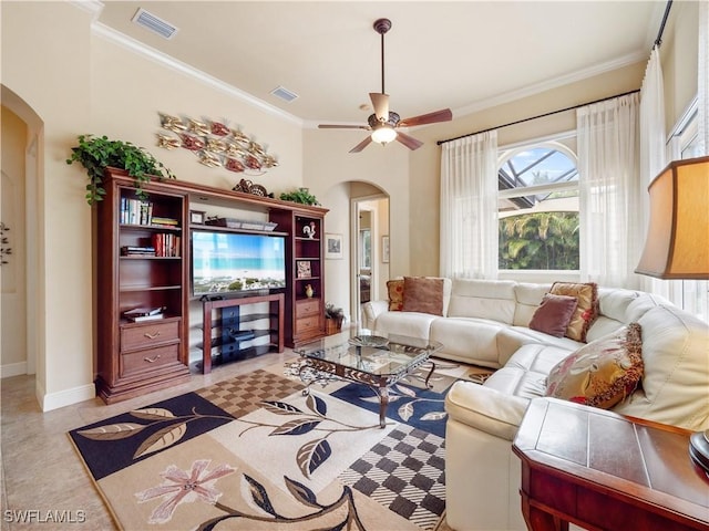 living room featuring arched walkways, visible vents, and crown molding