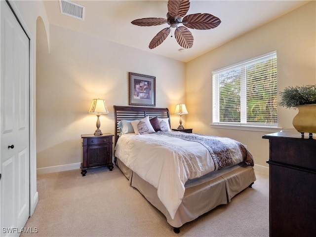 bedroom featuring a closet, light carpet, visible vents, and baseboards