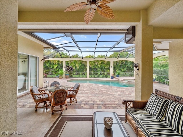 view of patio / terrace with a ceiling fan, a pool with connected hot tub, glass enclosure, and outdoor lounge area