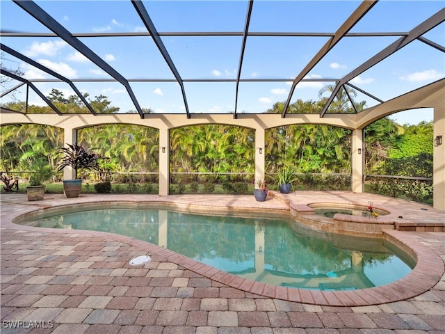 view of swimming pool with a pool with connected hot tub, a patio area, and a lanai