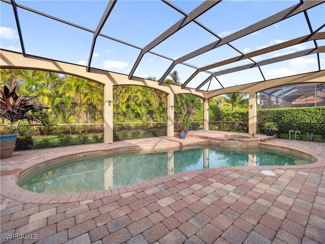 view of swimming pool with glass enclosure, a pool with connected hot tub, and a patio area