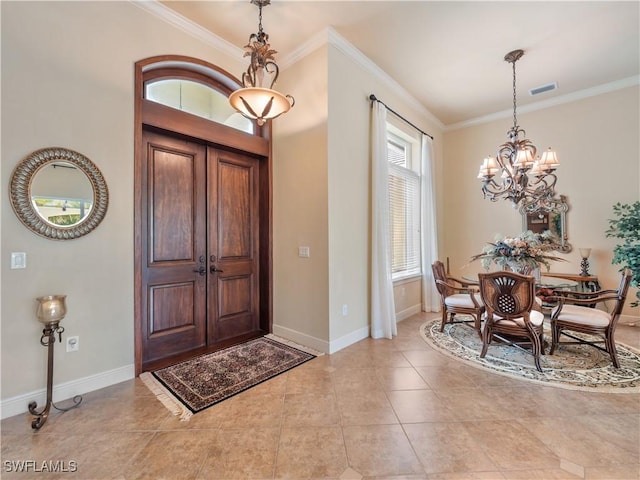 foyer entrance with ornamental molding, a chandelier, light tile patterned flooring, and baseboards