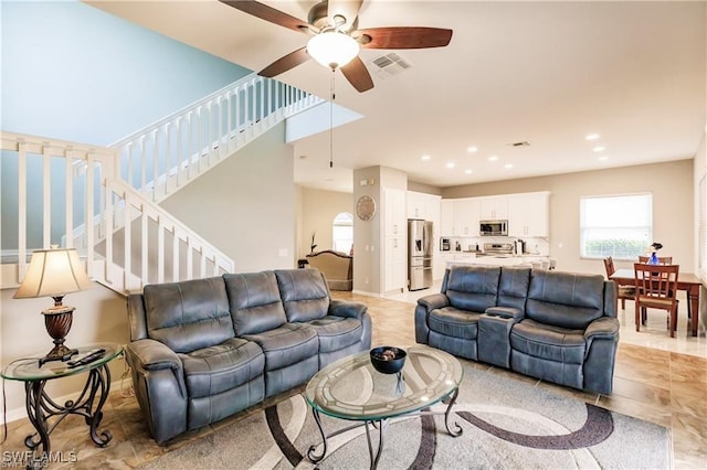 living area with recessed lighting, visible vents, a ceiling fan, baseboards, and stairs