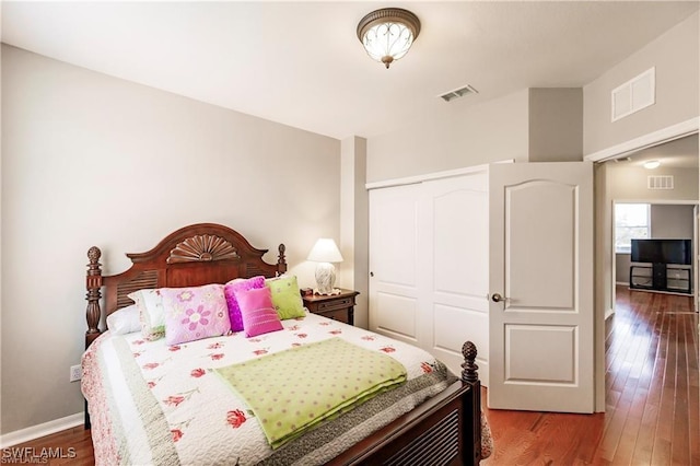 bedroom featuring a closet, wood finished floors, and visible vents