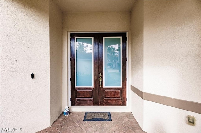 entrance to property with french doors and stucco siding