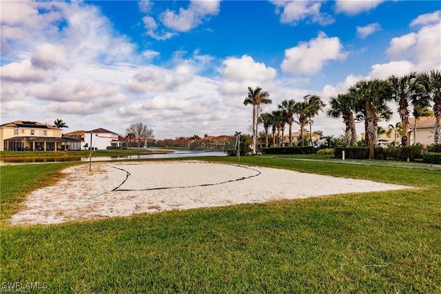 surrounding community with volleyball court and a lawn