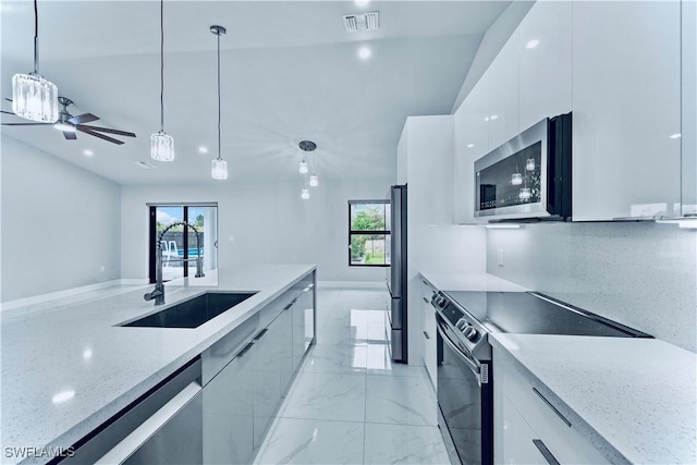 kitchen with light stone counters, white cabinets, appliances with stainless steel finishes, modern cabinets, and pendant lighting