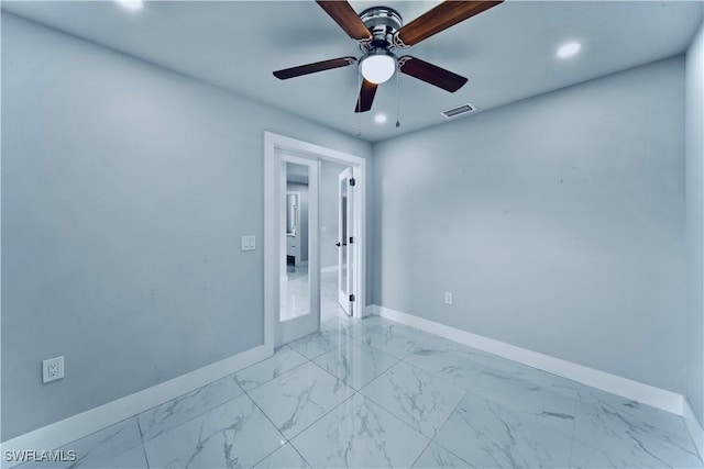 empty room with marble finish floor, recessed lighting, visible vents, and baseboards