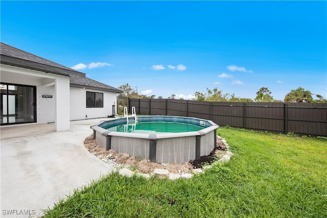 view of swimming pool with a fenced in pool, a fenced backyard, and a lawn