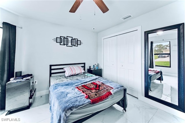 bedroom featuring ceiling fan, visible vents, baseboards, marble finish floor, and a closet