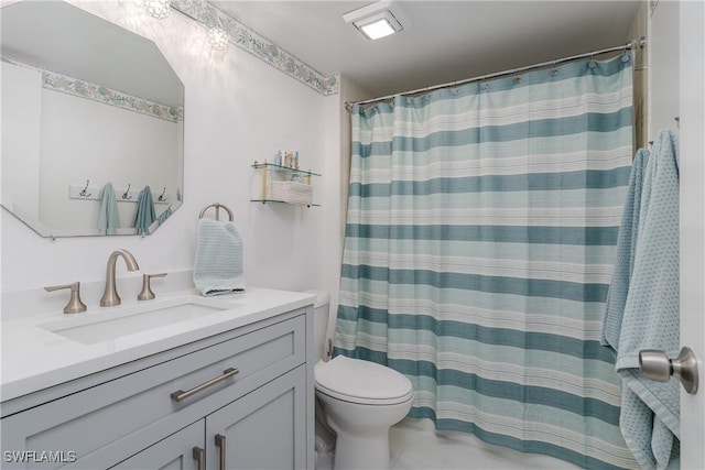 bathroom with curtained shower, vanity, and toilet