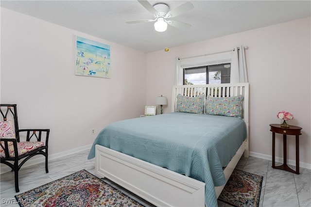 bedroom with marble finish floor, ceiling fan, baseboards, and a textured ceiling