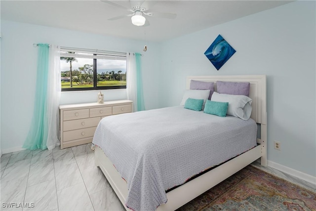 bedroom featuring a ceiling fan, marble finish floor, and baseboards