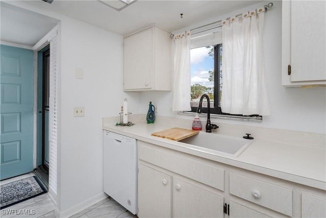 kitchen featuring marble finish floor, light countertops, white cabinetry, a sink, and dishwasher