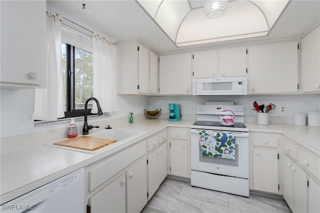 kitchen featuring light countertops, white appliances, a sink, and white cabinetry