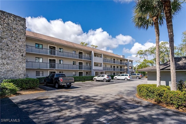 view of building exterior with uncovered parking