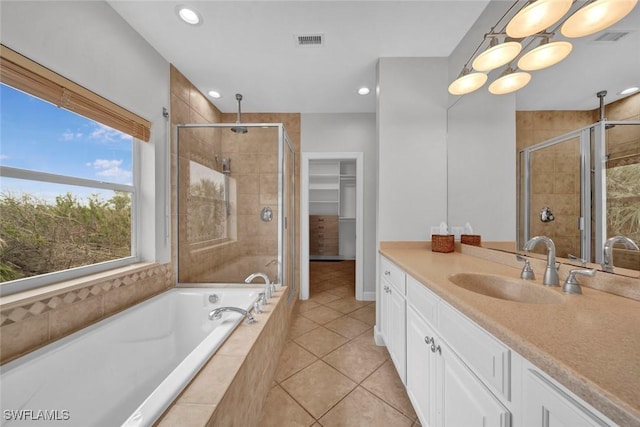 bathroom with vanity, a walk in closet, visible vents, and a shower stall