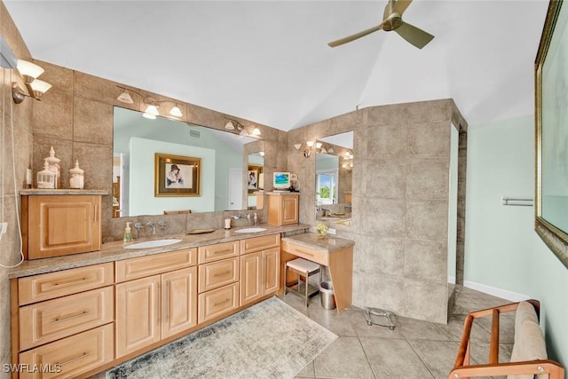 bathroom featuring vaulted ceiling, a sink, tile walls, and tile patterned floors