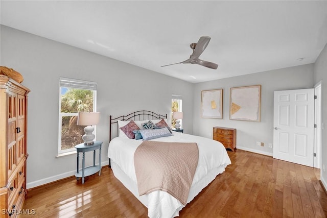 bedroom featuring a ceiling fan, baseboards, and wood finished floors