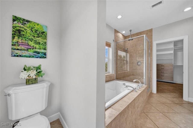 bathroom with a garden tub, tile patterned flooring, visible vents, a shower stall, and a walk in closet