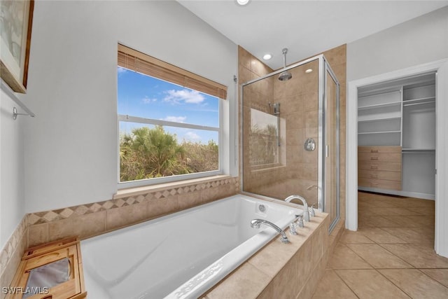 full bath with tile patterned flooring, recessed lighting, a bath, a stall shower, and a walk in closet