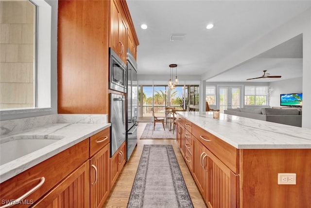 kitchen featuring a kitchen island, brown cabinets, hanging light fixtures, stainless steel appliances, and recessed lighting