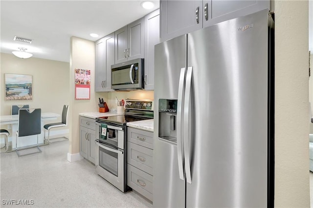 kitchen featuring visible vents, appliances with stainless steel finishes, light speckled floor, and gray cabinetry