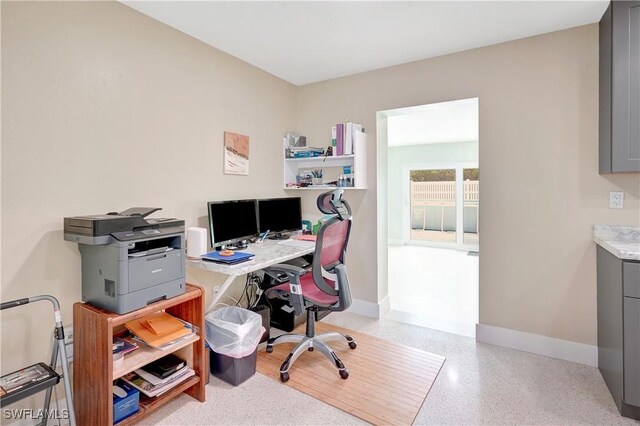 home office with light speckled floor and baseboards