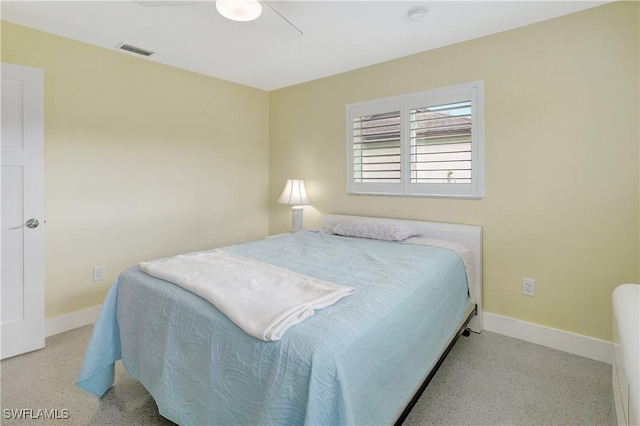 bedroom with speckled floor, visible vents, and baseboards