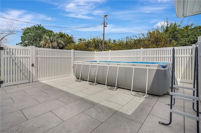 view of patio featuring a gate, fence, and a fenced in pool