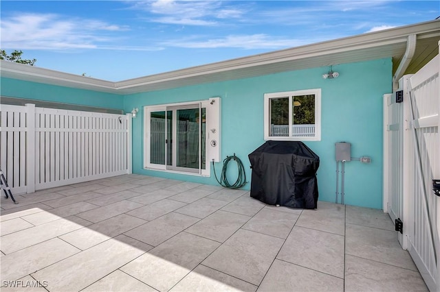 rear view of property featuring a patio area, fence, and stucco siding