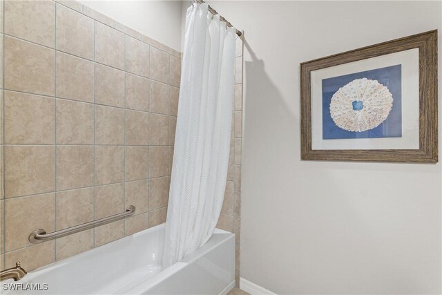 bathroom featuring shower / bath combo with shower curtain and baseboards