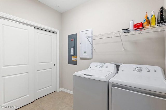 laundry room featuring electric panel, laundry area, baseboards, and separate washer and dryer