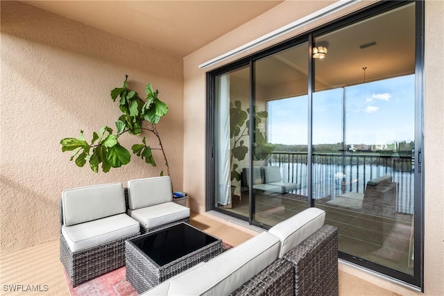 exterior space with a water view, a balcony, and outdoor lounge area