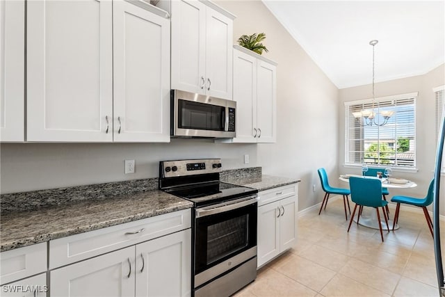 kitchen with stainless steel appliances, baseboards, a chandelier, vaulted ceiling, and white cabinetry