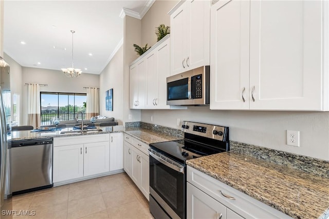 kitchen featuring crown molding, appliances with stainless steel finishes, an inviting chandelier, white cabinets, and a sink